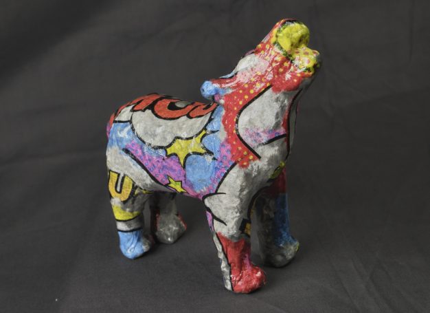 Bunt bemalte Figur, die einen Hund oder Wolf darstellt.