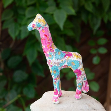 Kleine Pappmachée-Giraffe mit buntem Blumenmuster,  Decoupagetechnik